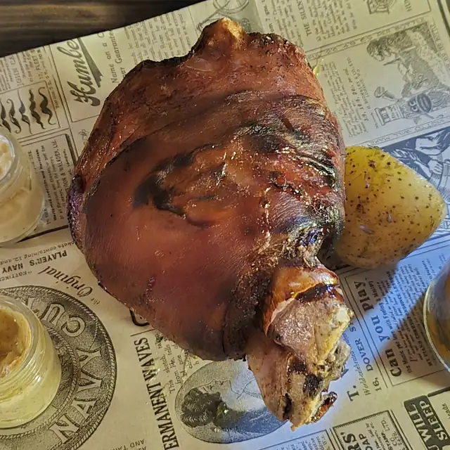 Pieczona golonka na desce z musztardą i chrzanem
